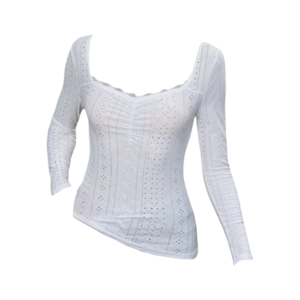 White long- sleeve top with sweetheart neckline, intricate embroidery, and eyelet details, paired with jeans for a stylish and elegant look.