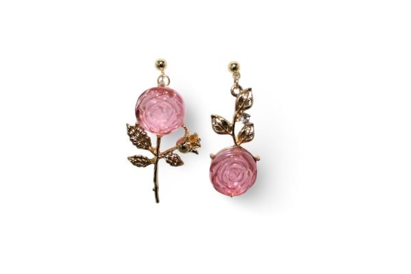 Our earrings feature a delicate rose design crafted from pink resin with intricate gold stems and leaf details.
