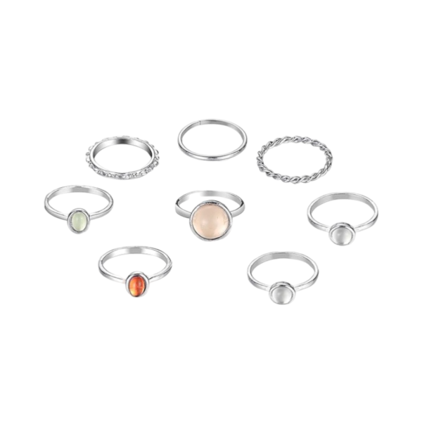 A collection of silver-tone rings featuring a variety of designs, including smooth bands, twisted details, and bezel- set stones in shades of white, orange, and green.