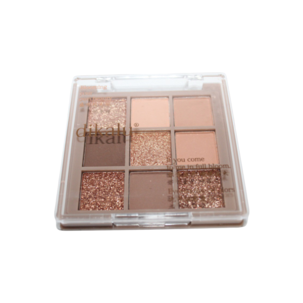 Eyeshadow palette with nine shades, including a mix matte and glitter finishes in neutral and gold tones.